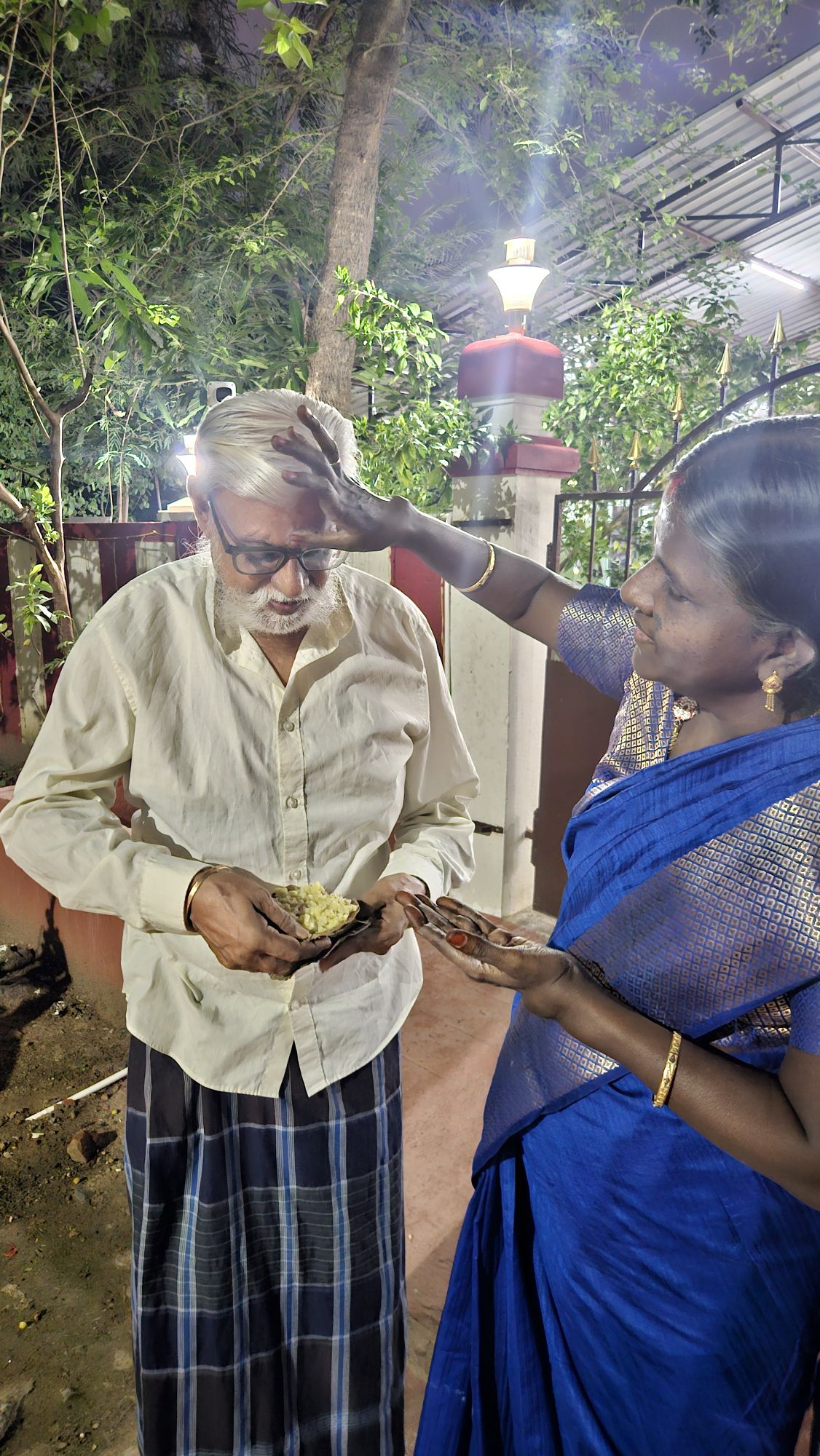 palanijothi (my mom) applies thiruneer on my dad's forehead. 